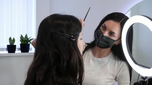 Woman Styles Eyebrows in Beauty Salon