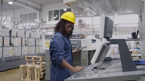 Focused Black Factory Employee Operating Industrial Machine