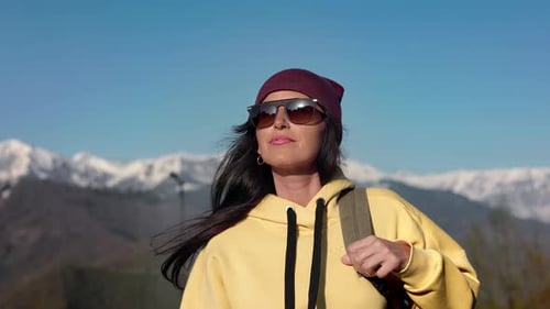 Stylish Beautiful Brunette Travel Woman in Sunglasses Walking at Snowy Mountain Nature Landscape