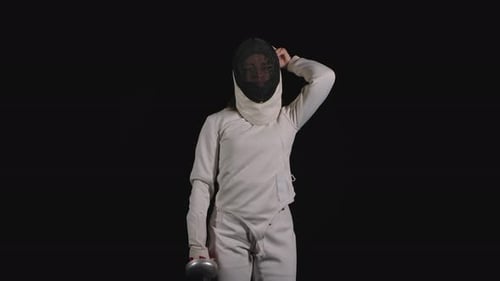 Portrait of a Professional Woman Fencing Athlete Which Puts on a Protective Mask and Becomes in a