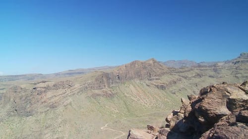 Young Woman Doing Yoga Atop Rocky Mountain