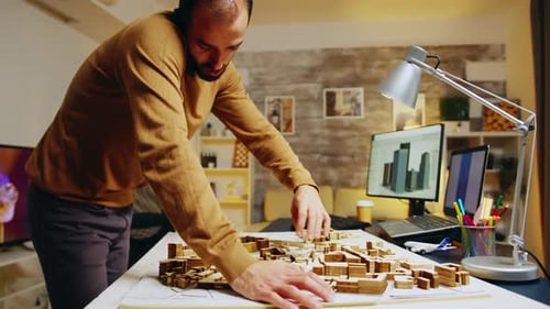Architect Adjusting Wooden Building Model at Home