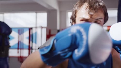 Front view of caucasian man working out in boxing gym