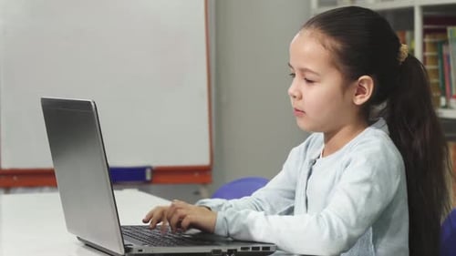 Cute Child Uses Laptop for Education at School