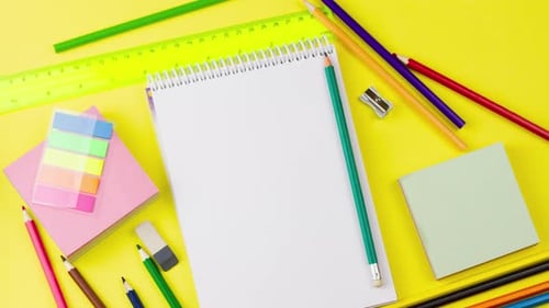 a White Blank Notepad Lies on a Pastel Yellow Background