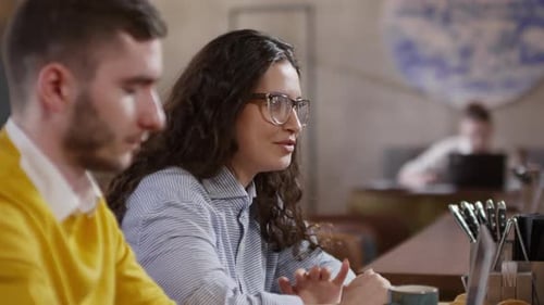 Cheerful Woman Chatting with Colleagues in Cafe