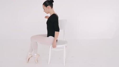 Ballerina in Black Performing with Chaior in White Studio Isolated