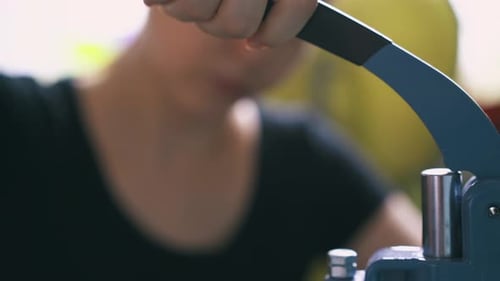 Woman operating manual press machine close up