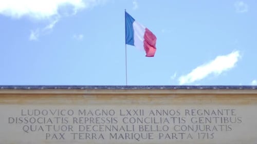 French Flag Waving Above Building