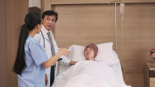 Doctors team health check a male patient in inpatient room bed of hospital ward.