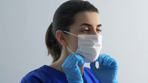 Healthcare Worker Putting on Mask and Safety Glasses
