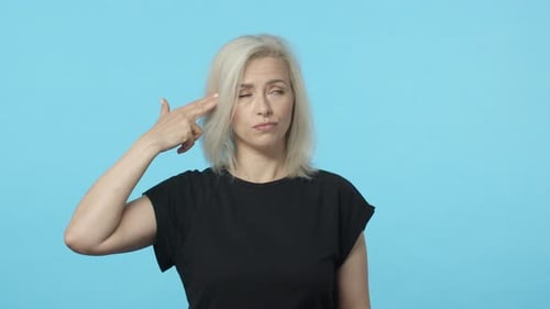 Zeitlupe, genervt und gelangweilt, blonde Frau kann es nicht mehr aushalten, Fingerpistole, Pistole, Geste und