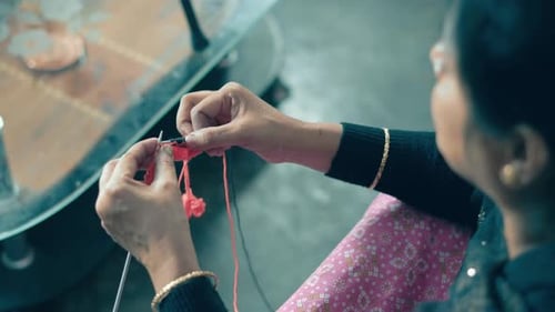 Woman start knitting with black wool after row in red color. Footage from above of knit work tie-up