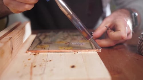 Artist soldering Glass Frame with Flowers