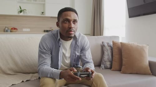 Man Playing Video Game on Couch in Living Room