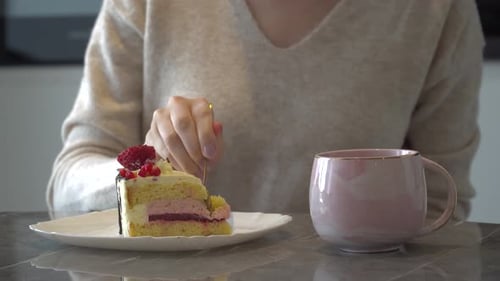 A Young Girl Eats A Cake With Tea In A Cafe