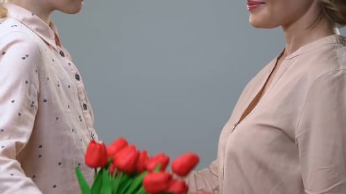 Child Gives Bouquet of Tulips to Woman