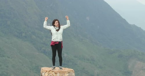 Woman Reaching the Top Of Mountain