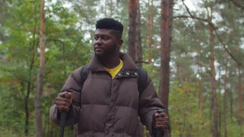African Hiker with Trekking Poles Walking in Wood