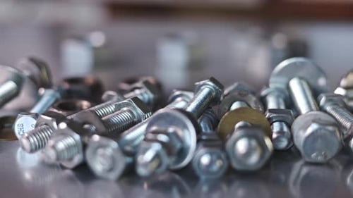 Slider Shot Video of Chrome Bolts and Nuts in a Chaotic Order Industrial Background