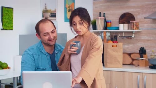 Couple Using Laptop Together in Home Kitchen