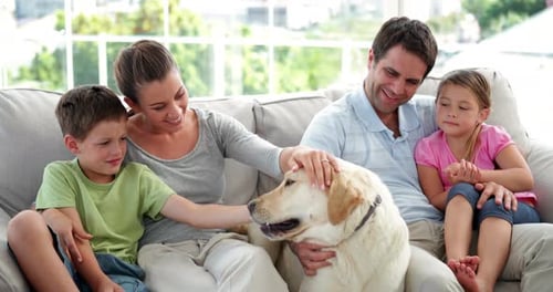Happy Family Relaxing with Dog on Couch