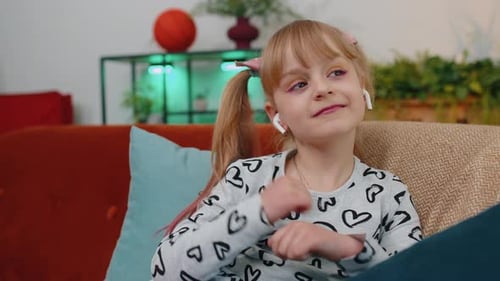 Girl Listening to Music on Couch with Headphones