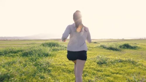Woman Running in Green Field, Sunny Day
