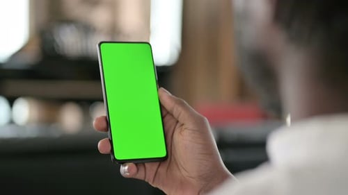 Rear View of African Man Using Smartphone with Chroma Key Screen