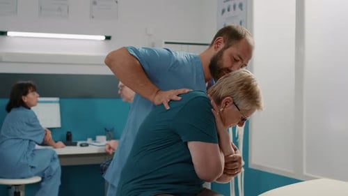 Medical Professional Assists Senior Woman With Arm Stretches