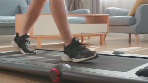 Person Walking on Treadmill Inside Modern Home