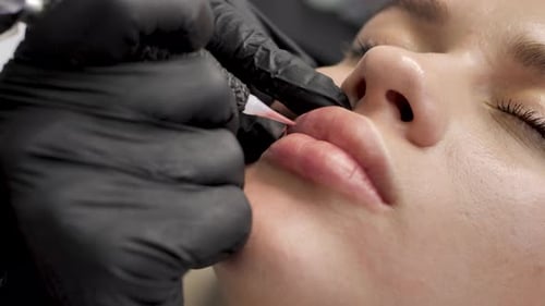 Eine Kosmetikerin schminkt die Lippen in einem Schönheitssalon permanent