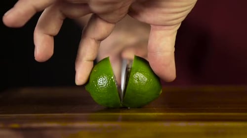 Adult Hands Cut Lime on Cutting Board