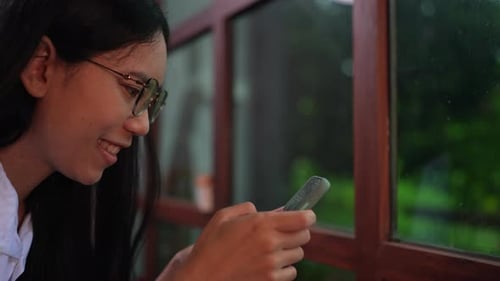 Smiling Woman Using Smartphone Indoors