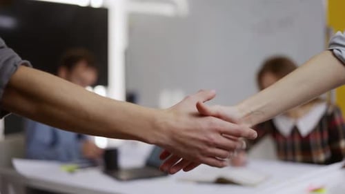 Business Handshake Over Desk in Office