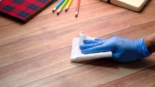 Hand with Glove Wipes Wooden Table