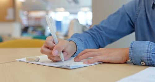 Woman write on the paper at library