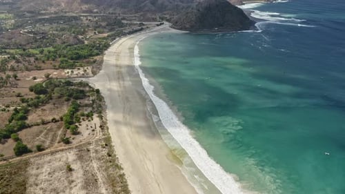 Scenic Aerial View of Sandy Coast and Waves Forming White Foam in Indonesia