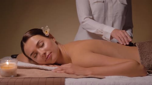 Schöne Frau mit einer Hot-Stone-Massage im Spa