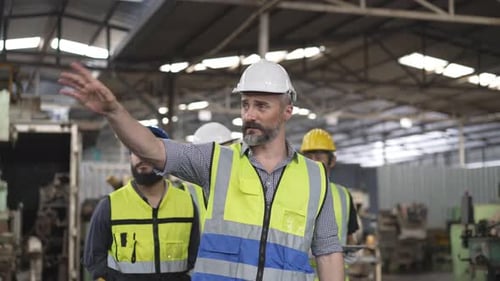 Team of Engineers Walk Through a Factory