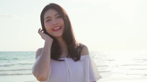 Beautiful female happy relax walking on beach near sea when sunset in evening.