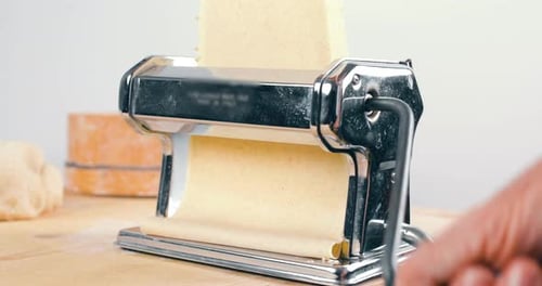 Dough Being Rolled Through Pasta Machine Close Up