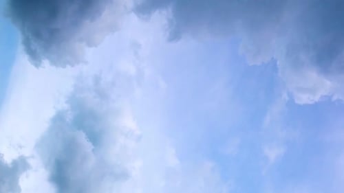 Flauschige Wolken in einer nahtlosen Schleife am blauen Himmel im Sommer, aufgenommen an einem sonnigen Tag