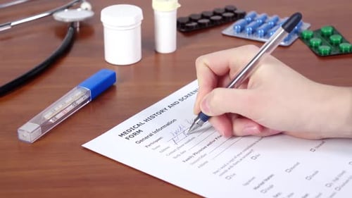 Doctor Writing a Medical History and Screening Form of the Patient