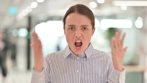 Retrato de una mujer joven agresiva que se comporta enojada, luchando