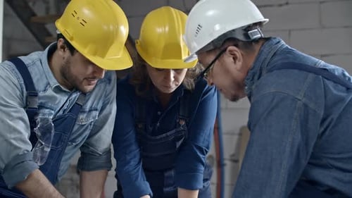 Gruppe von Bauherren diskutiert Layoutplan