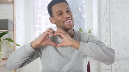 Man Makes Heart Shape with Hands, Smiling