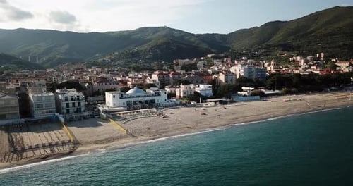 Drone view of the Mediterranean with a sandy beach, town, and mountains. aerial view