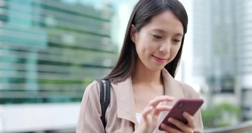 Smiling Woman Using Smartphone in Urban Setting