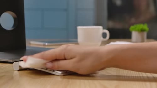 A Woman Sprays an Antiseptic on the Surface of the Keyboard and Thoroughly Cleanses It of Dangerous
